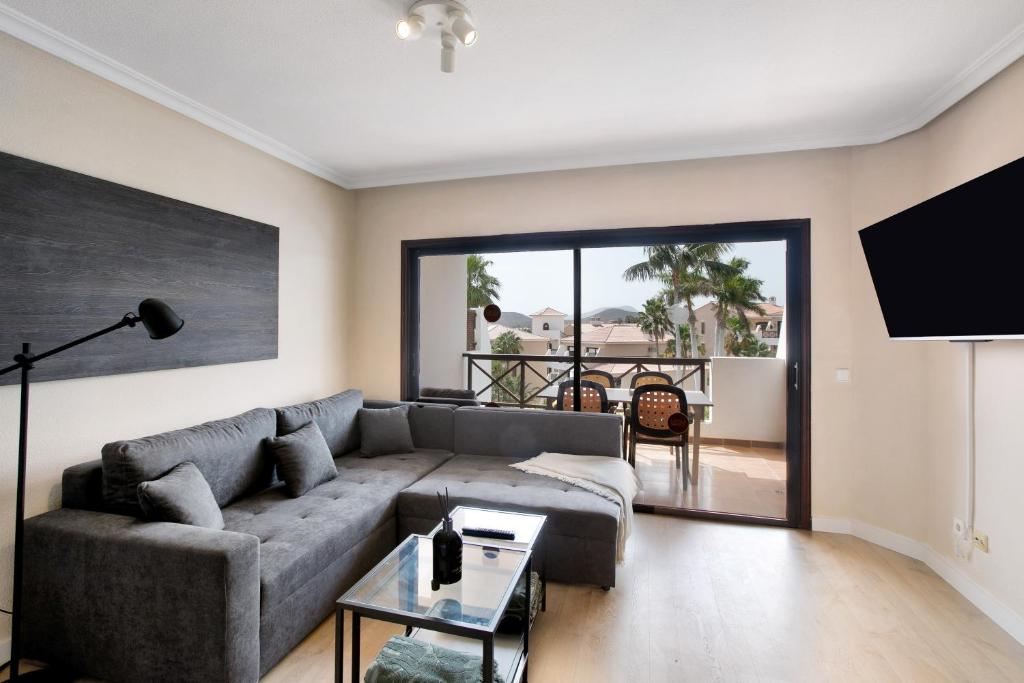 Una sala de estar con un sofá y un televisor. en Apartamento Royal Park Albatros, en San Miguel de Abona
