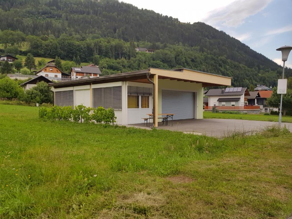 una casa en un campo con una montaña en el fondo en Kleblach 90, 9753 Lind im Drautal, en Kleblach