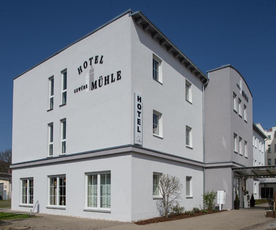 Hotel Gewürzmühle في غيرا: مبنى ابيض مكتوب عليه اكوام دقيقة