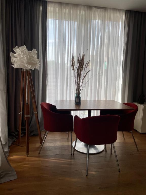 uma sala de jantar com uma mesa e cadeiras vermelhas em SURF HOUSE DREAMERS COAST em Klaipėda