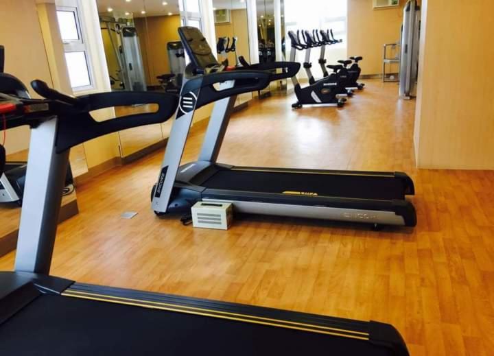 un gimnasio con una fila de máquinas de cardio en una habitación en 101 Newport Boulevard -Terminal 3 Airport, en Manila