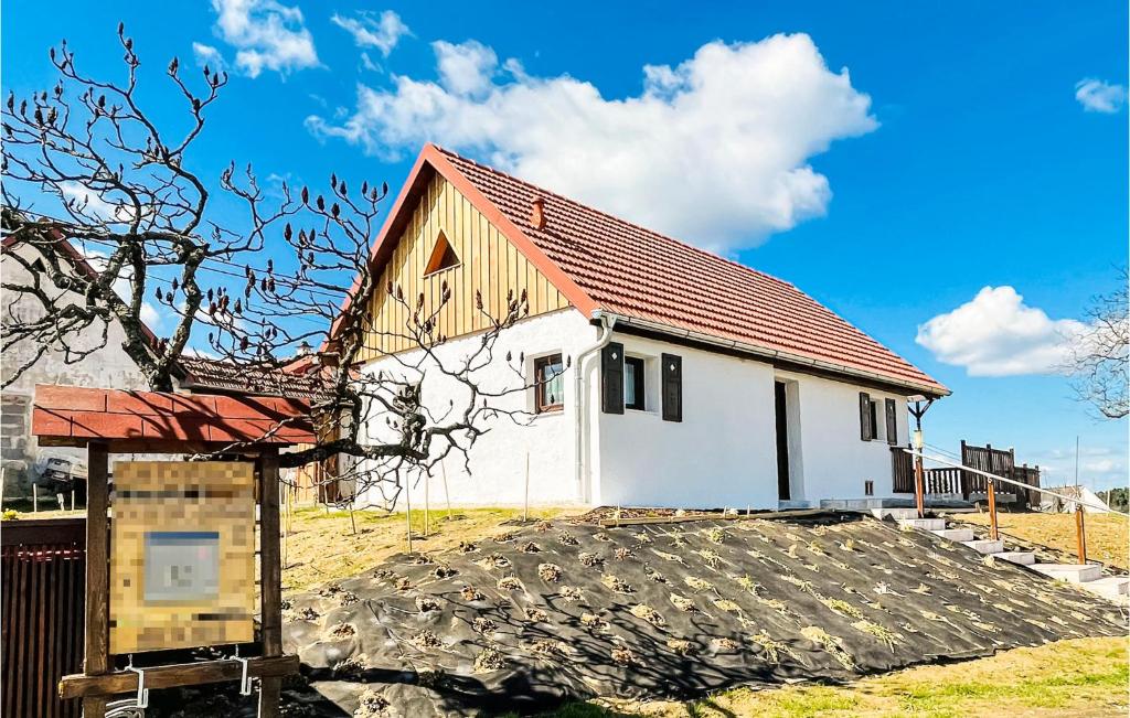 Beautiful Home In Stegersbach With Kitchen في شتيغرسباخ: مبنى ابيض صغير بسقف احمر