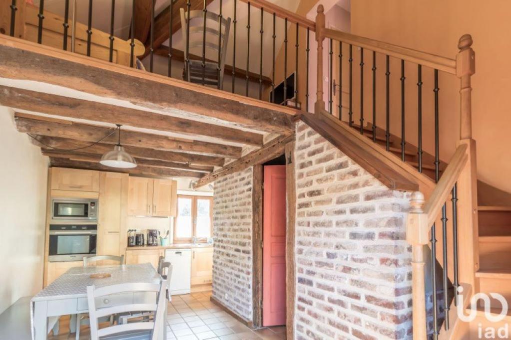 eine Treppe in einer Küche mit Ziegelwand in der Unterkunft Les Pins - Maison avec parking ferme et jardin commun au calme in Saint-Prix