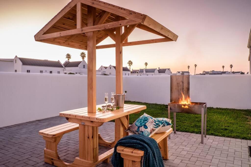 a wooden pergola with a table and a grill at Whale & Tortoise - Lampiesbaai in St Helena Bay