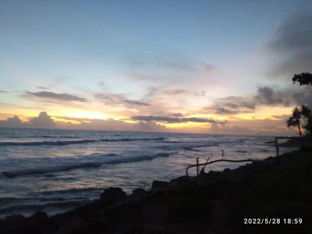 um pôr-do-sol sobre o oceano com o oceano em Devi Kripa Residency em Varkala