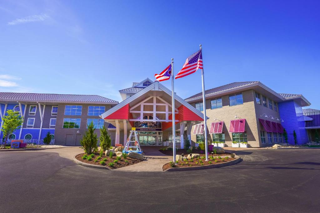 a hotel with two flags in front of a building at Castaway Bay by Cedar Point Resorts in Sandusky