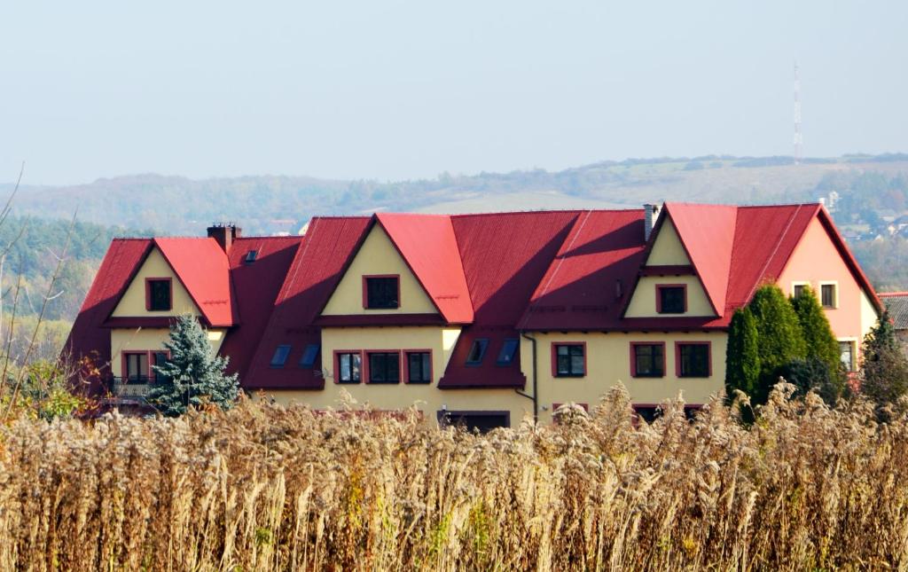 una casa con techos rojos en la parte superior de un campo en NOCLEGI Grojec, 