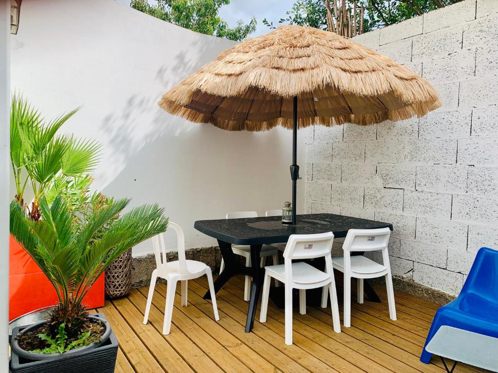 a patio with a black table and chairs and an umbrella at EL PEPITA, Sublime maison de ville, Rennes in Rennes