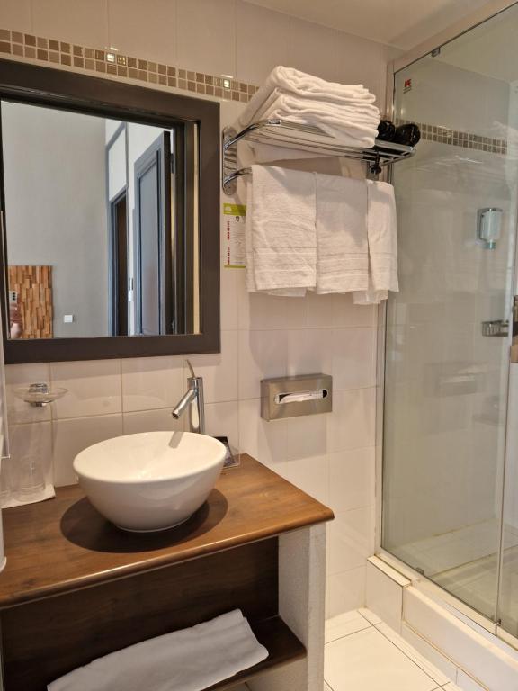 a bathroom with a white sink and a shower at Hôtel La Villa Tosca in Cannes