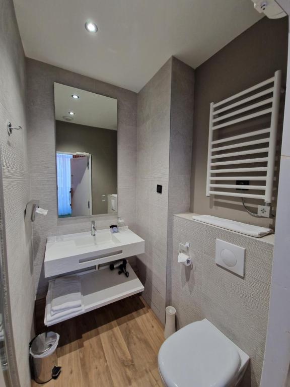 a bathroom with a sink and a toilet and a mirror at Hôtel La Villa Tosca in Cannes