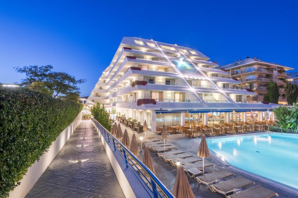 un hotel con piscina y un edificio en Hotel Montemar Maritim, en Santa Susanna