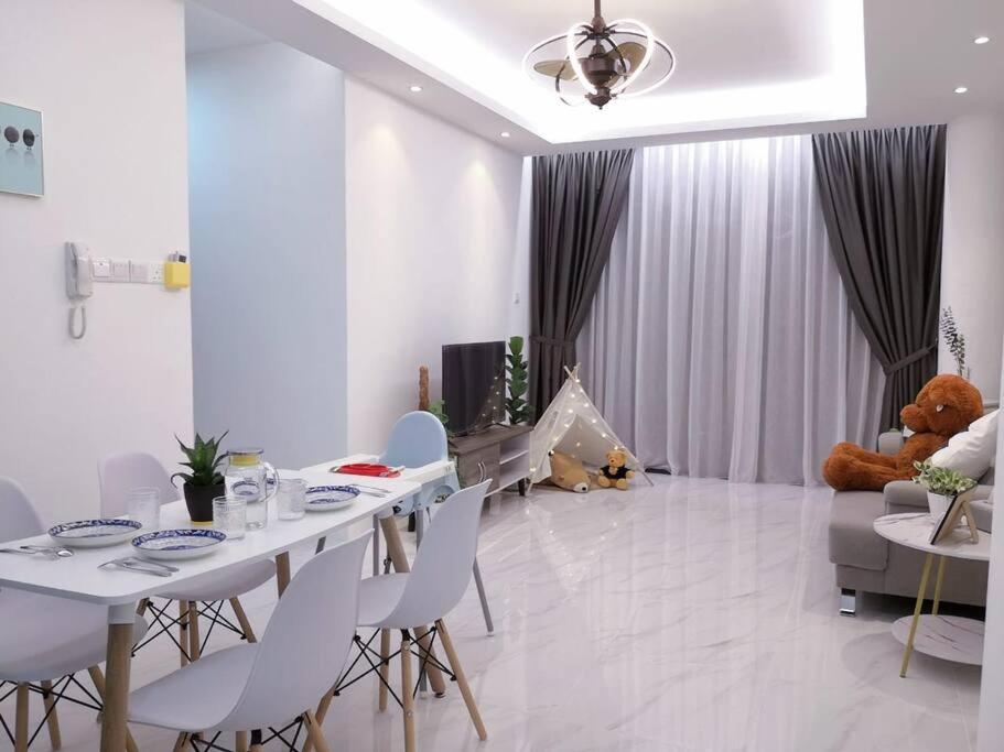 - un salon avec une table, des chaises et un ours en peluche dans l'établissement Hanns&KingBed&WIFI&Pool& Parking&Sauna&Sunshine Classic Comfort Homstay, à Sibu