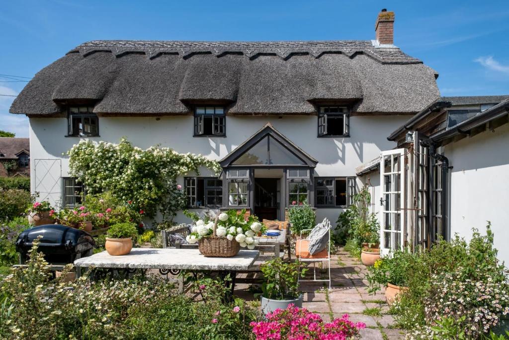 an old cottage with a thatched roof at Thatched Hat Cottage in Lymington