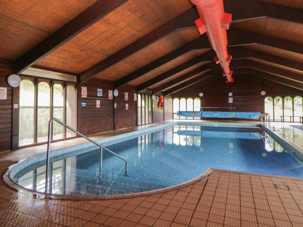 a large indoor swimming pool in a building at Harcombe House Bungalow 5 in Newton Abbot