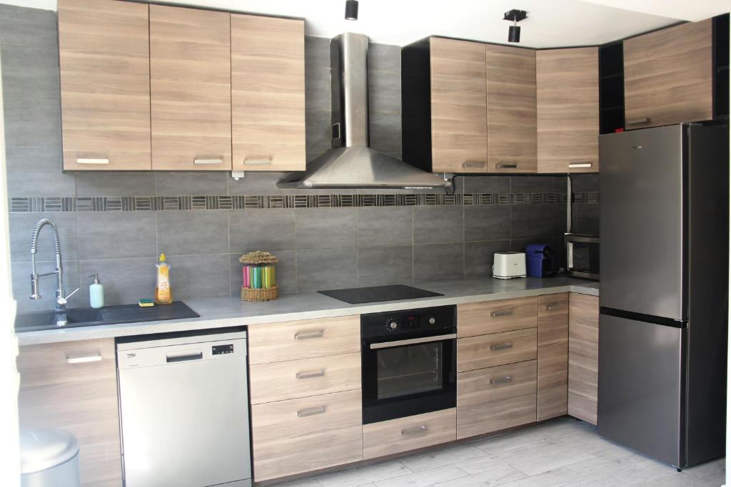 a kitchen with stainless steel appliances and wooden cabinets at Cosy 1 bedroom Appt Proche de tout Metro à pied in Boulogne-Billancourt