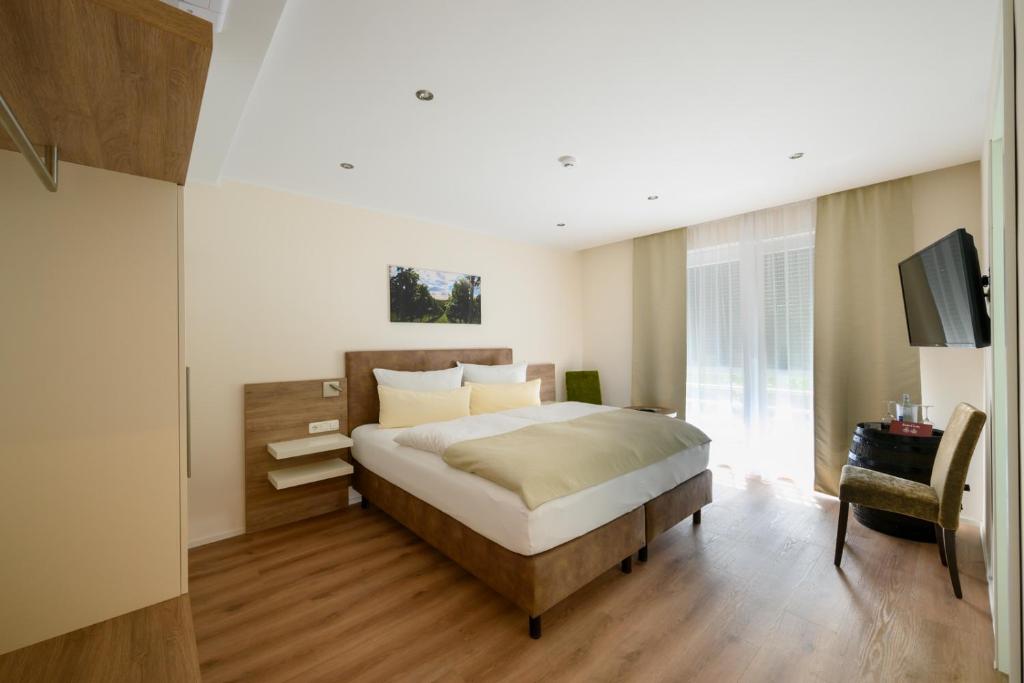 1 dormitorio con 1 cama grande y TV en Gästehaus zum Weintraum, 