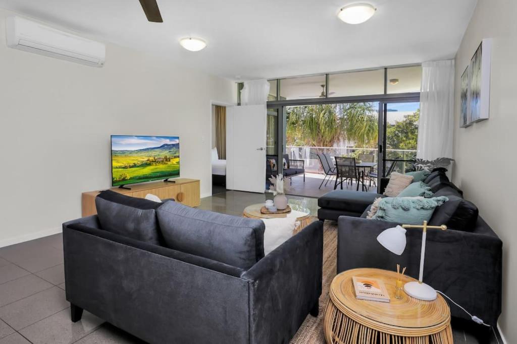 Sala de estar con 2 sofás y mesa en Pool View City Centre Apartment 202 en Cairns