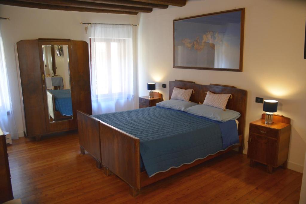 1 dormitorio con 1 cama con edredón azul en Accogliente locale con terrazzo in centro storico, en Vittorio Veneto