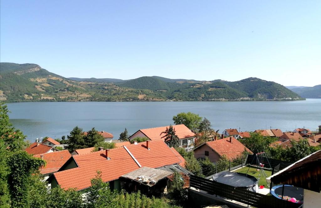 a view of a town with orange roofs and a lake at NIKAS Apartman in Donji Milanovac