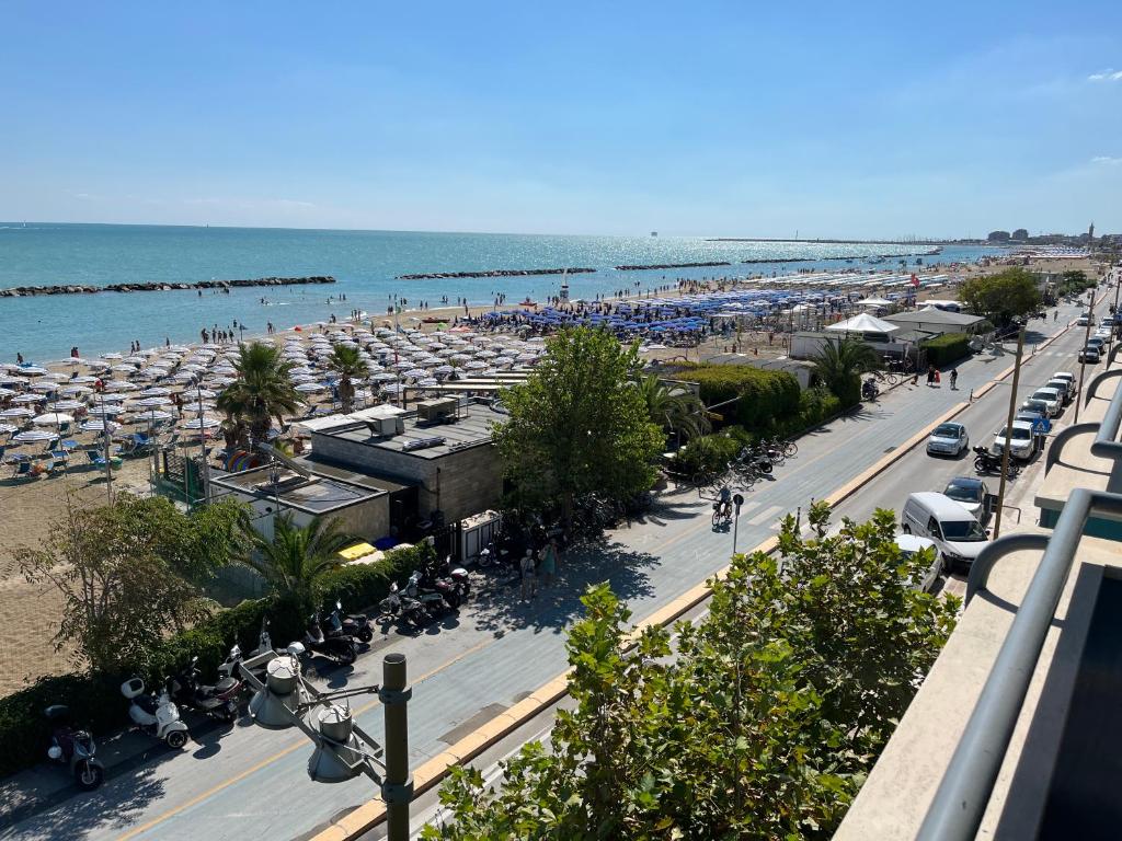 una spiaggia con molti ombrelloni e auto sopra di Appartamento Fronte Mare a Civitanova Marche