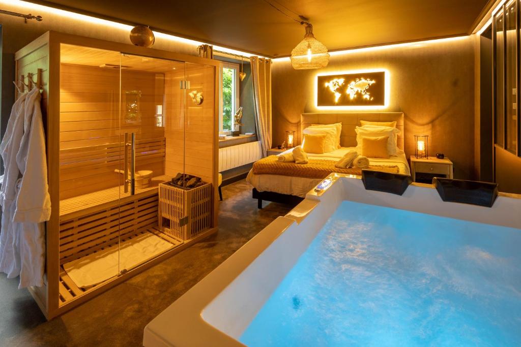 a bedroom with a tub and a bed and a shower at La Suite - Spa & Sauna in Kaysersberg