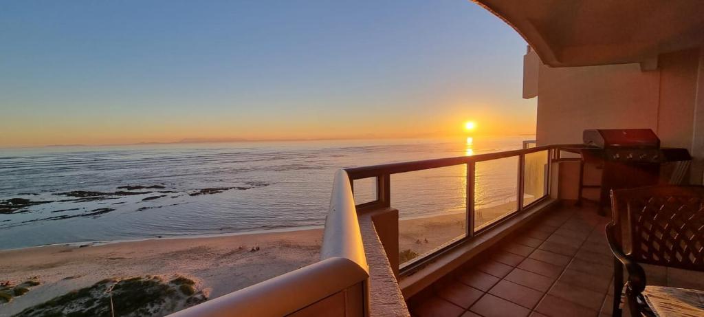 un balcón con vistas al océano al atardecer en Strand Beach Front, en Strand