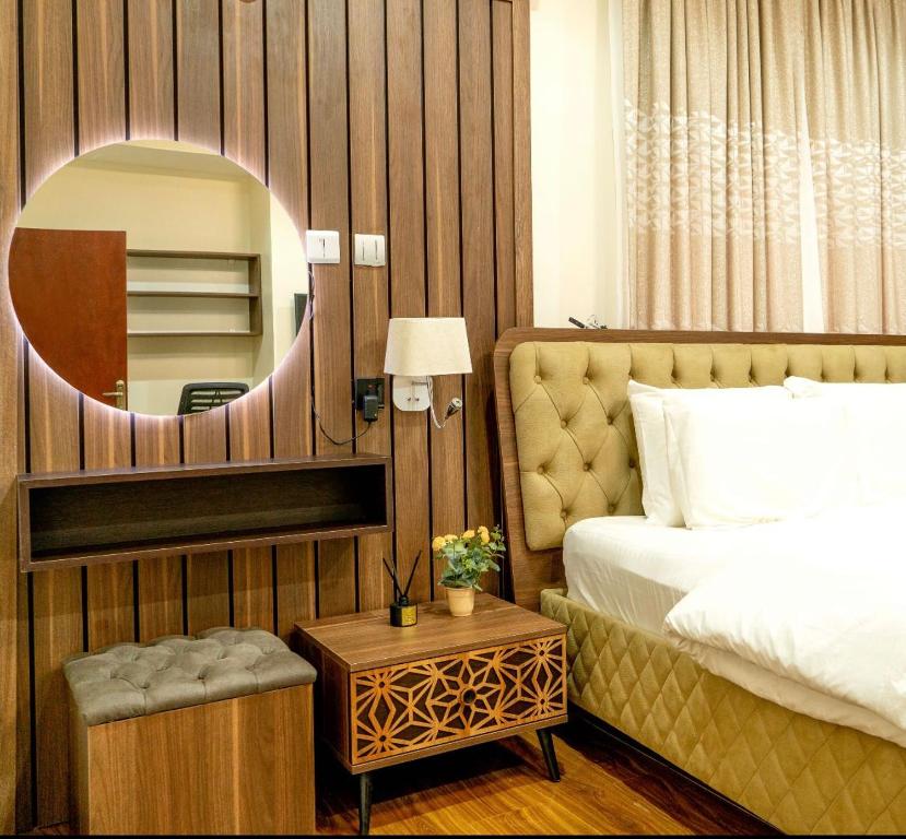 a bedroom with a bed and a mirror and a table at Integral Consults Apartment in Abuja