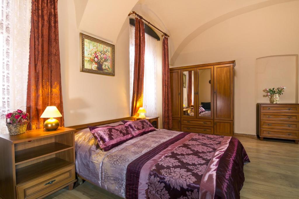 a bedroom with a bed and a dresser and a mirror at Penzión Grand in Košice