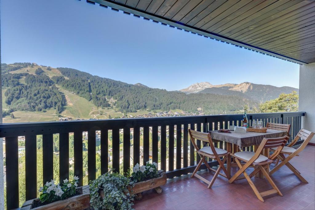 a patio with a table and chairs on a balcony at Les Marmottes du Morzena in Morzine