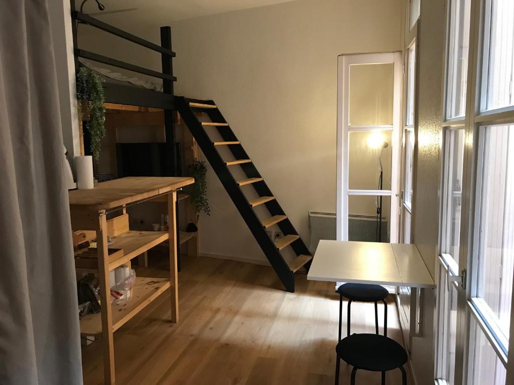 a room with a loft bed and a table and chairs at Studio hyper centre Toulouse in Toulouse