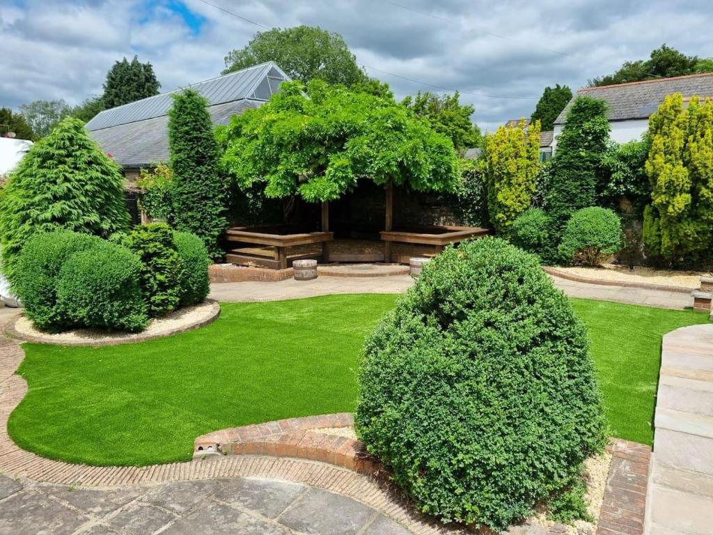 Elle offre une vue sur un jardin avec des buissons et des arbres. dans l'établissement Remarkable 4-Bed Cottage in Cearleon, à Newport