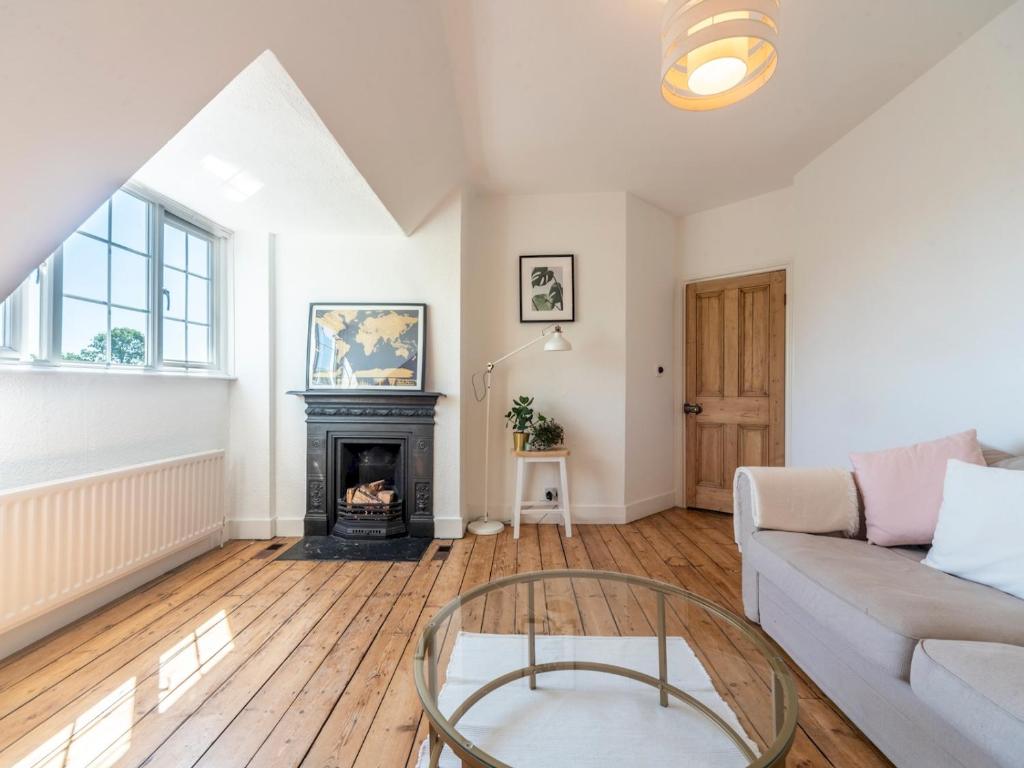 a living room with a couch and a fireplace at Pass the Keys Victorian Flat A Stones Throw From Hampton Court in East Molesey