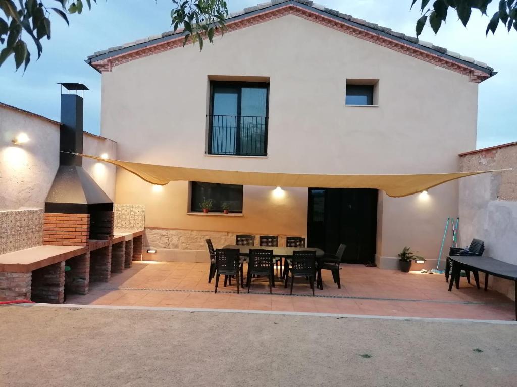 a patio with a table and chairs in front of a house at El Niu de l'Estany in Ivars d'Urgell