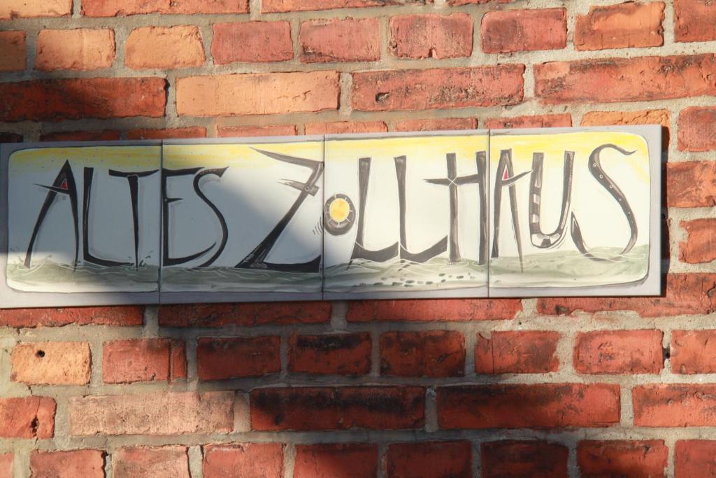 a sign on a brick wall with the word artichoke at Altes Zollhaus Stralsund in Stralsund