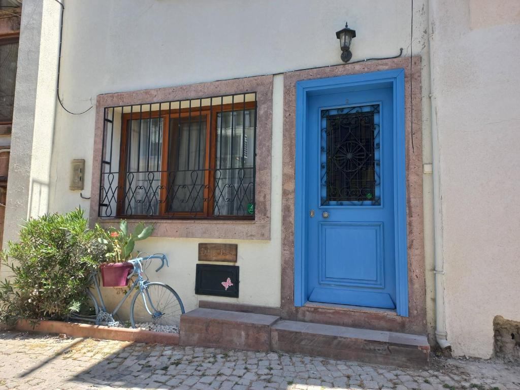 a blue door on the side of a building with a bike at Dalgaci Deniz Konukevi in Ayvalık