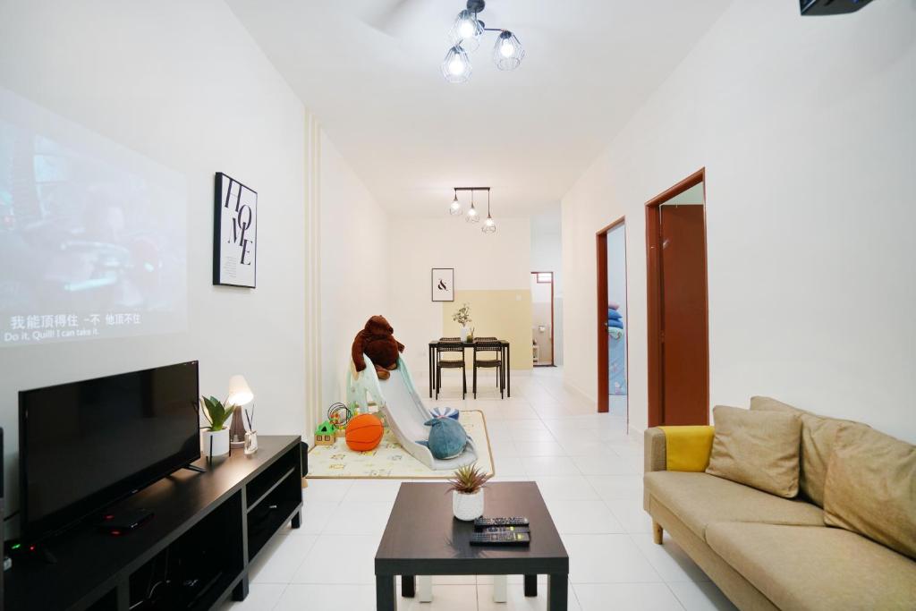 a living room with a woman sitting on a table at Desaru beach waterpark Tvbox By Joyfully 20b10 in Desaru