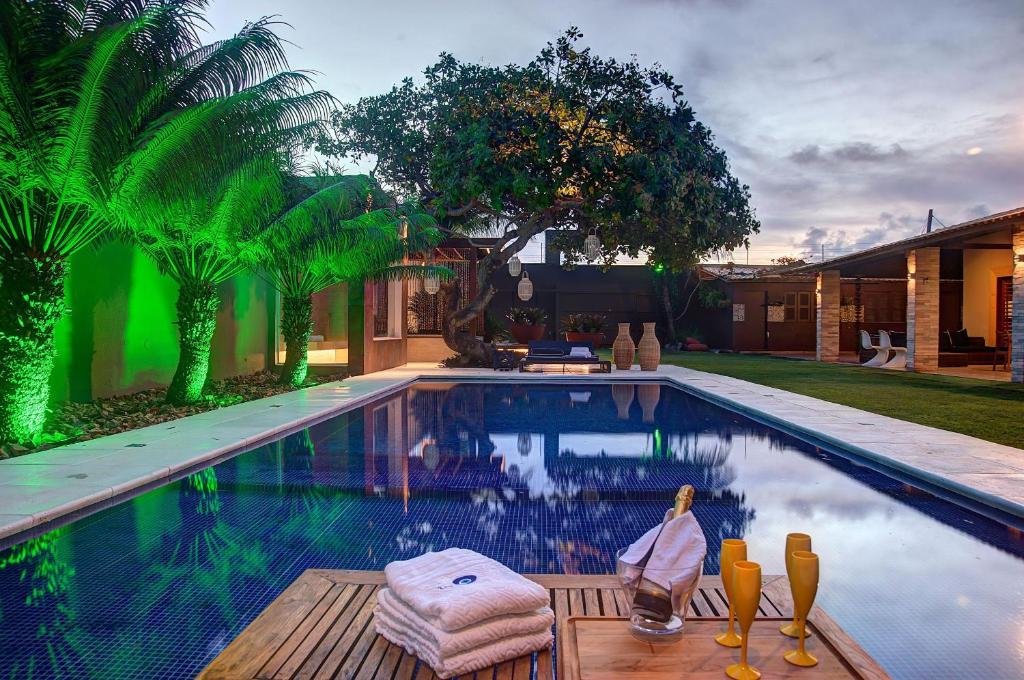 een zwembad met een tafel en stoelen naast een huis bij Casa Oásis com Sauna, Hidro e Piscina by Carpediem in Aquiraz