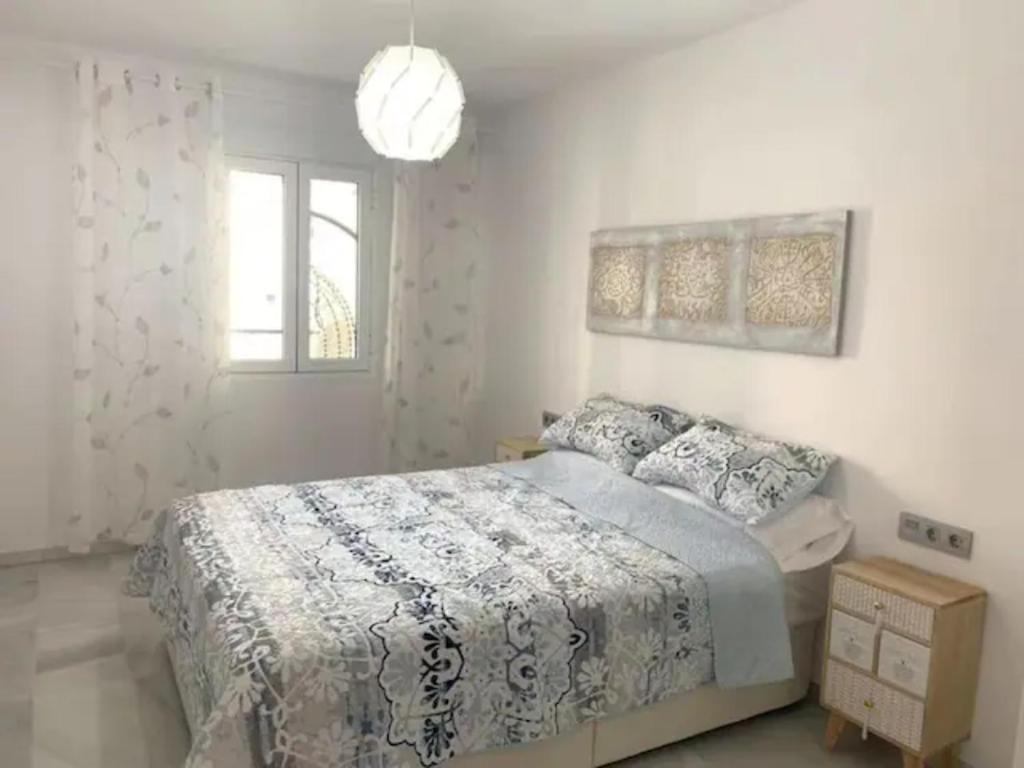 a white bedroom with a bed and a window at Apartamento Torremolinos parking gratis y terraza in Torremolinos