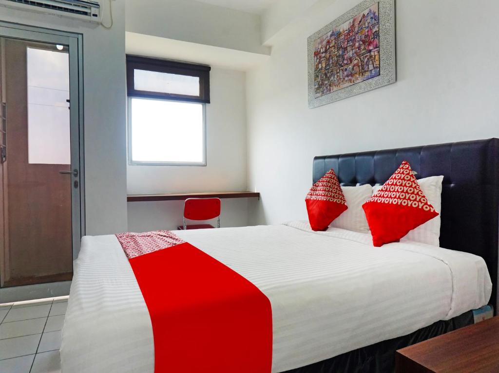 Un pat sau paturi într-o cameră la OYO 91593 San San Rooms Apartment Gunung Putri Square
