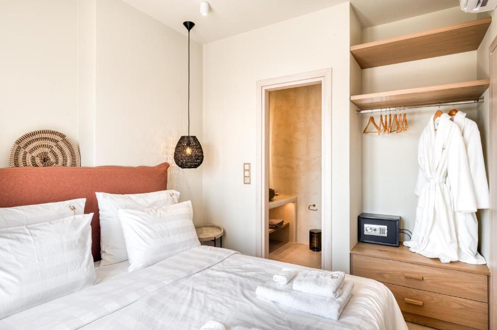 a bedroom with a white bed and a closet at Mirabelle Luxury Villas in Plaka