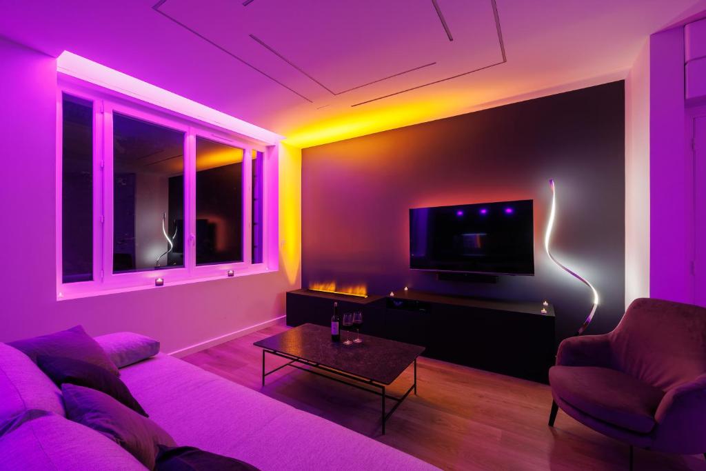 a living room with purple lighting and a couch at La Purple Suite in Marseille