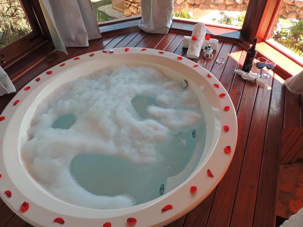 a bath tub with a cloud in it on a deck at Pousada Cantinho das Estrelas in Monte Verde