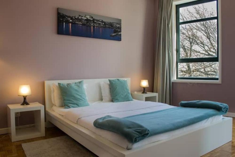 - une chambre avec un grand lit et des oreillers bleus dans l'établissement GuestReady - Cozy Boavista Studio 1B, à Porto