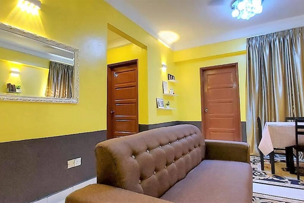 a living room with a couch and yellow walls at Comfy Stay @Permai Puteri Ampang nearby KLCC, IJN in Ampang