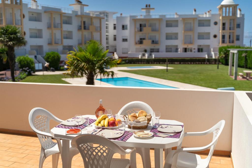 a white table with a plate of food on it at Casa Boa Onda in Nazaré