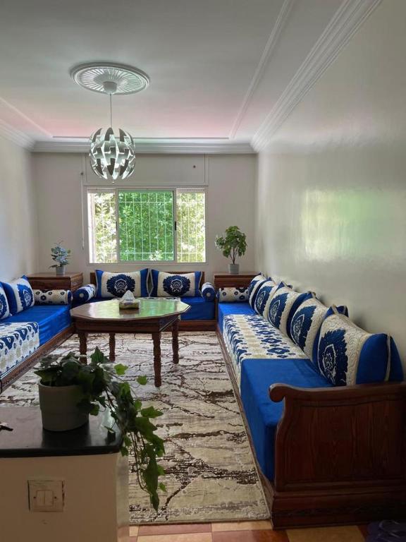 een woonkamer met een blauwe bank en een tafel bij Ifrane Appartment in Ifrane