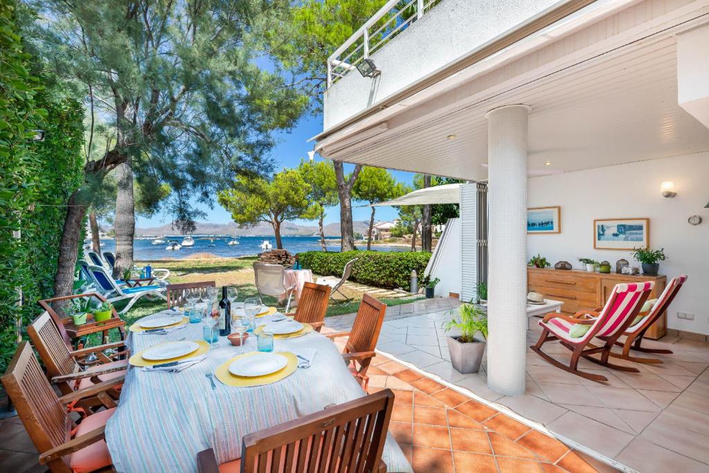 a patio with a table and chairs and the ocean at Camp de Mar in Alcudia