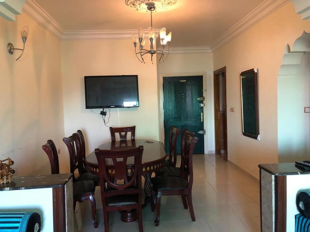 a dining room with a table and chairs and a television at Superbe Appartement centre vue sur mer . in Larache