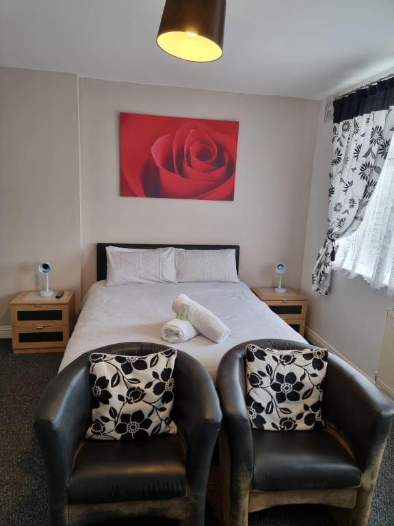 a bedroom with a bed with two leather chairs at Casablanca in Blackpool