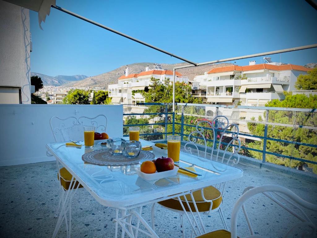 un tavolo bianco con frutta e bevande su un balcone di Lovely 50 sq penthouse & 25 sq balcony @ Glyfada ad Atene